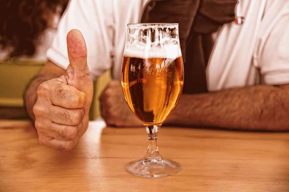 Our guide on buying a round of drinks shows a man giving a thumbs-up to a glass of beer.
